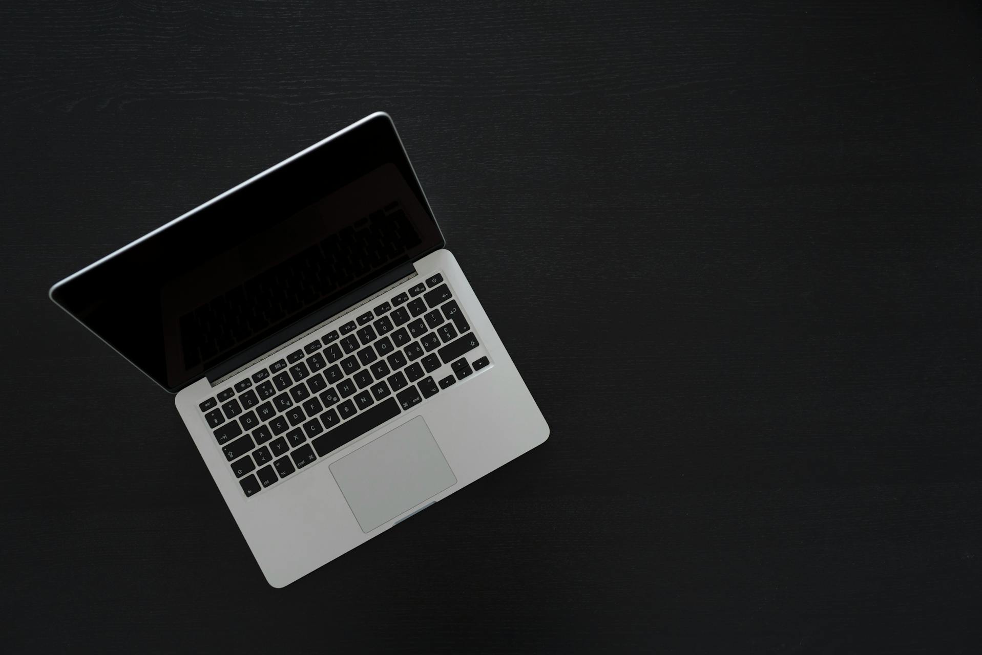 MacBook on a clean dark desk — the kind of setup that benefits from reproducible configuration